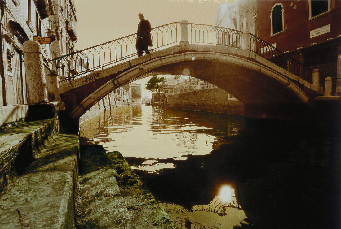 Man walking over Rio di San TrovasBridge in Venice, Italy