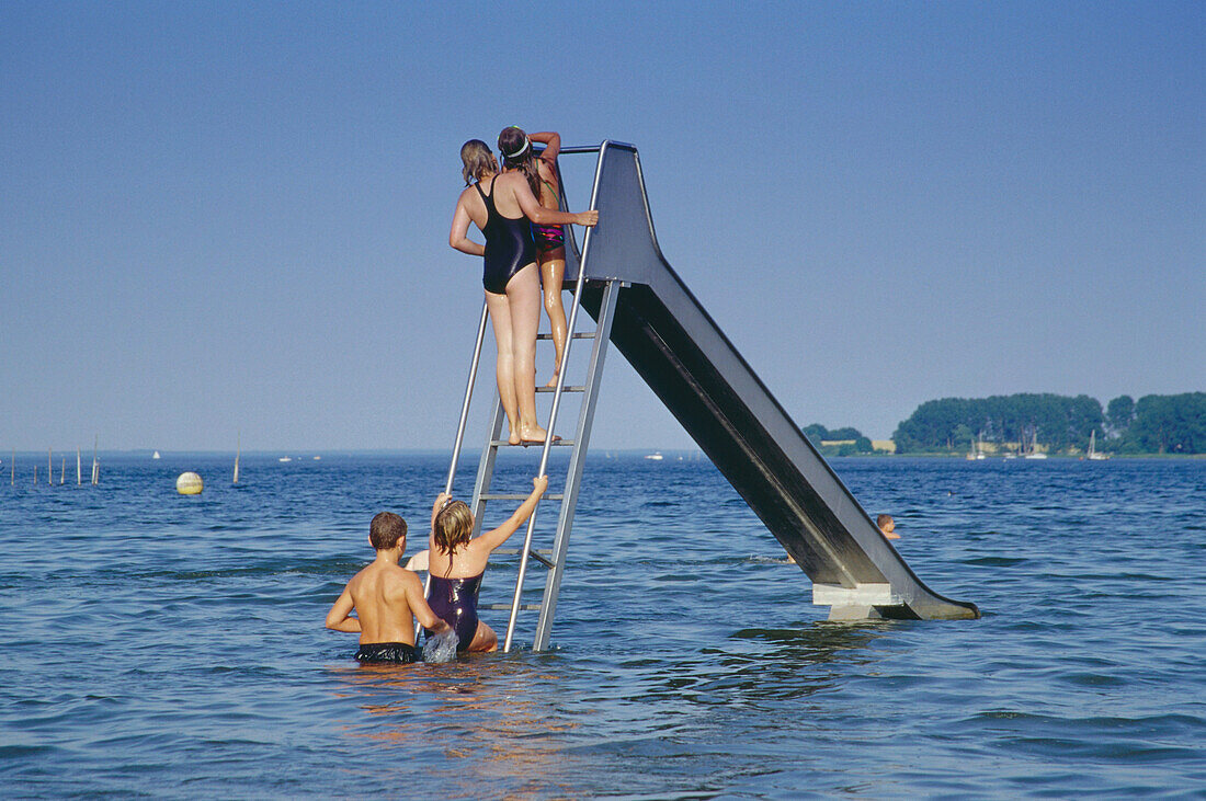 Bathing children on water slide, Mueritz Lake, Mecklenburgian Lake District, Mecklenburg-Western Pomerania, Germany