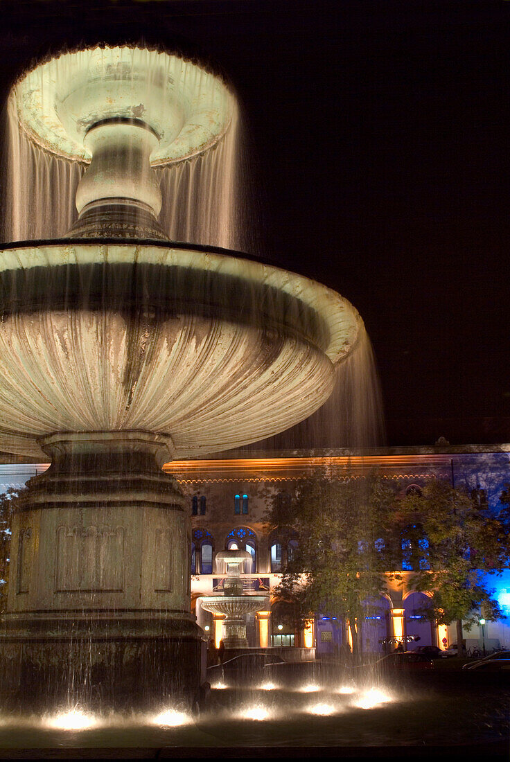 Illuminated fountain in front of University, Ludwigstrasse, Munich, Bavaria, Germany