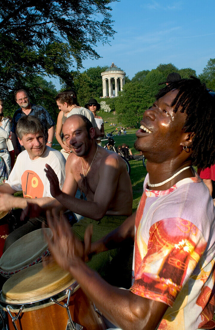 People drumming and dancing in the English Garden, Munich, Bavaria, Germany