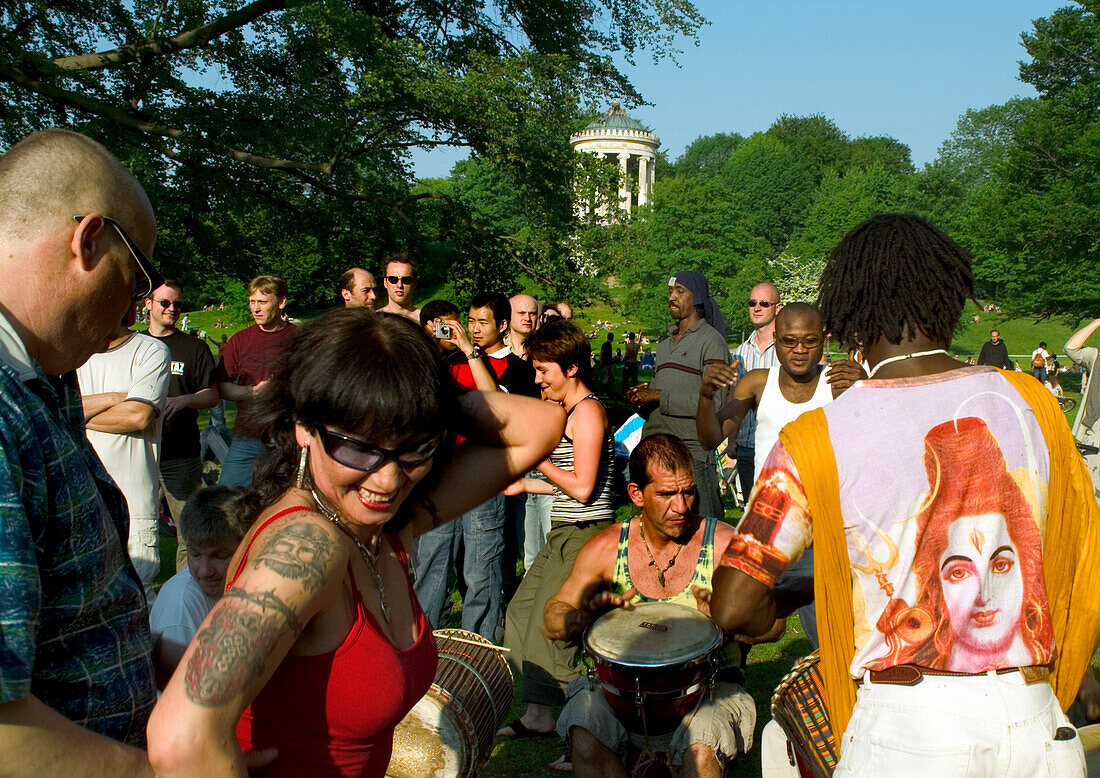 People drumming and dancing in the English Garden, Munich, Bavaria, Germany