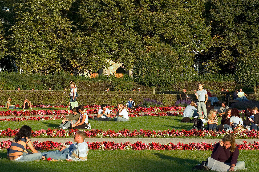 Young people relaxing in Hofgarten, Munich, Bavaria, Germany