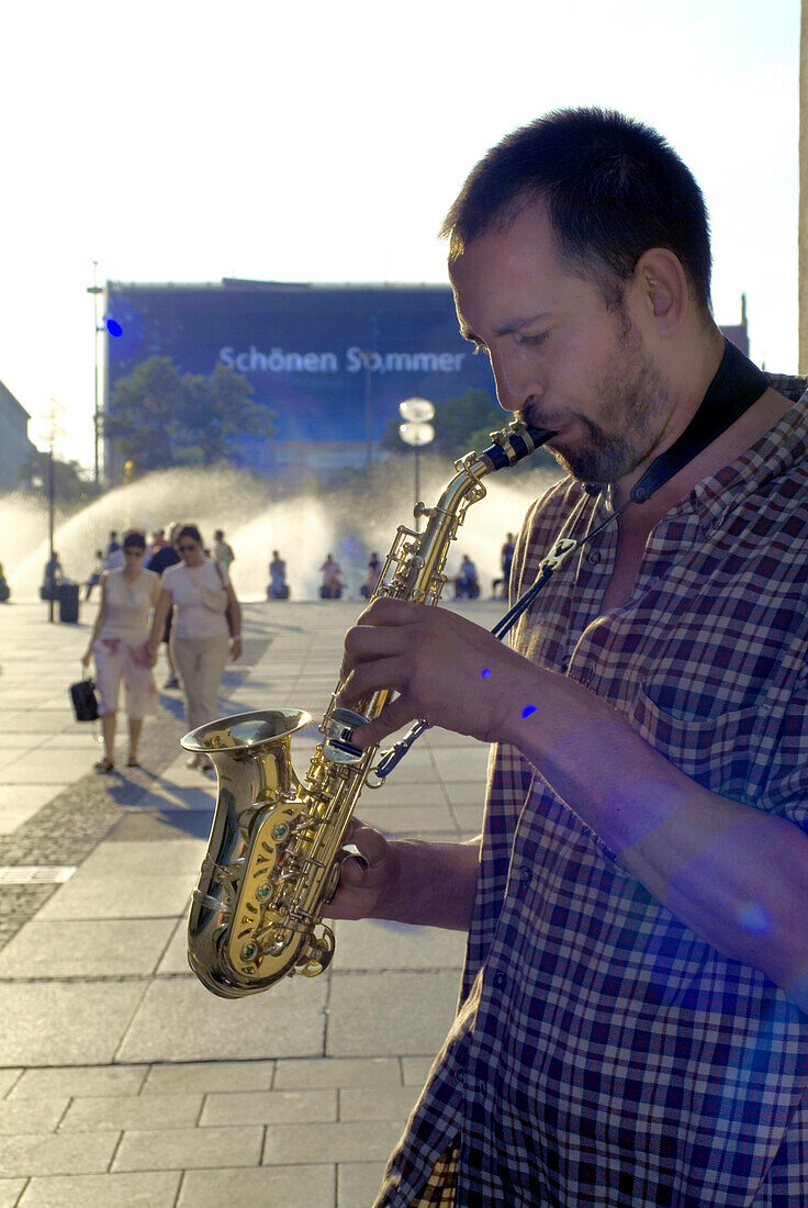 Musiker am Brunnen am Stachus, Street Musician playing Saxophone in front of Fountain at Stachus, Munich, Bavaria, Germany