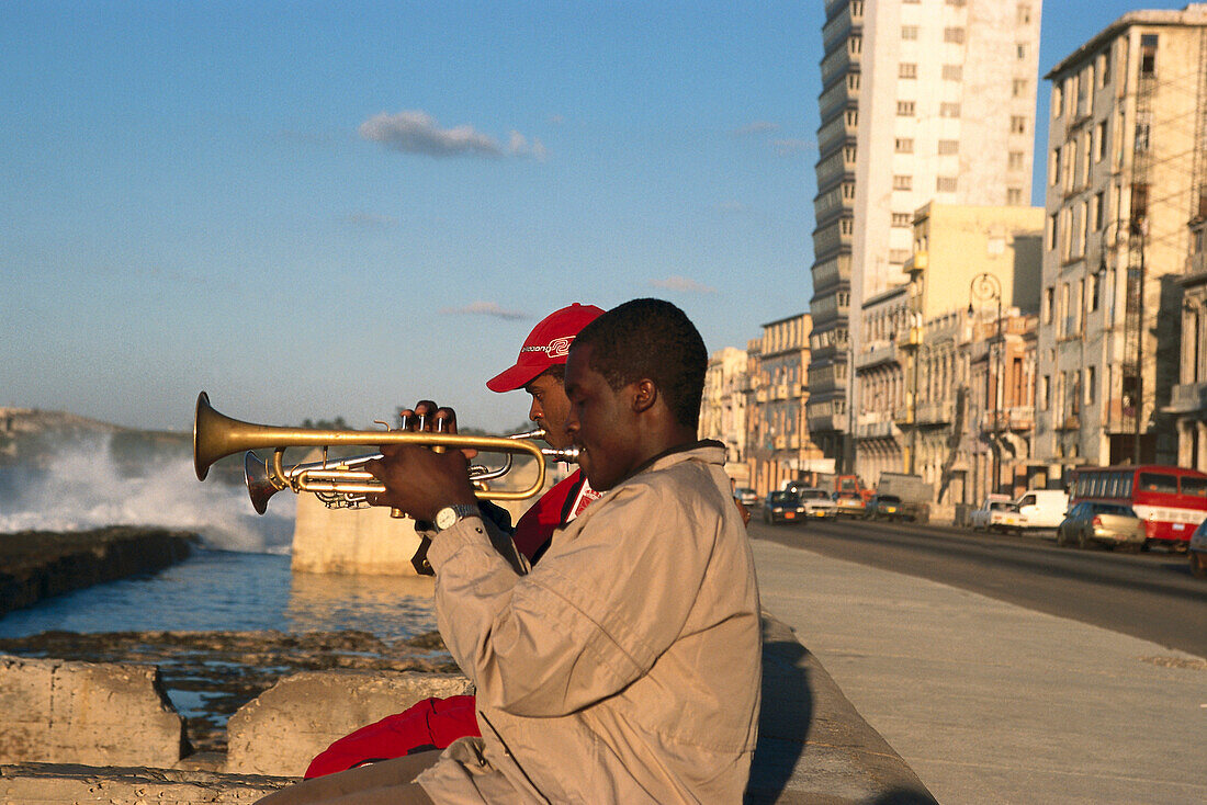 Männer spielen Trompete auf einer Ufermauer im Sonnenlicht, Malecon, Havanna, Kuba, Amerika