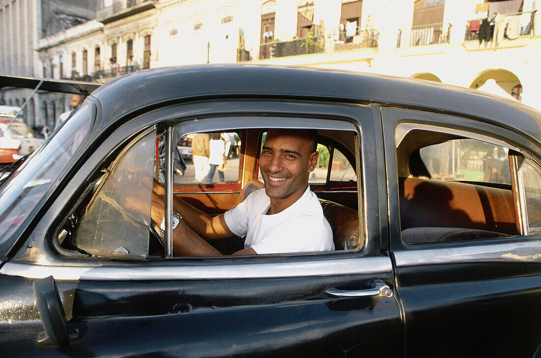 Ein Mann schaut lächelnd aus einem Auto, Prado, Havanna, Kuba