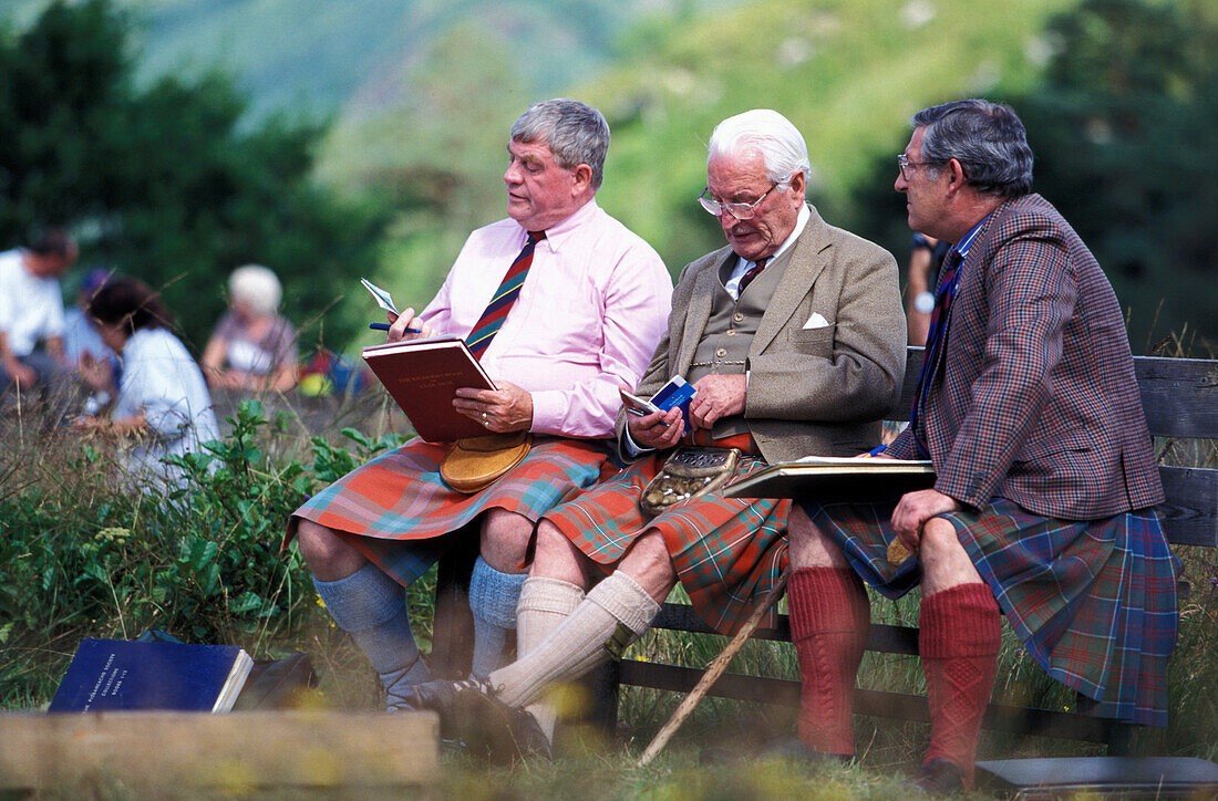 Men in kilts on a bench, judges at Glenfinnan Highland Games, Glenfinnan, Scotland, Great Britain, Europe