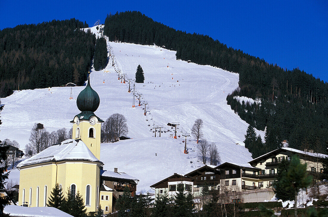 View of ski slope and church of Saalbach, Salzburger Land, Austria, Europe