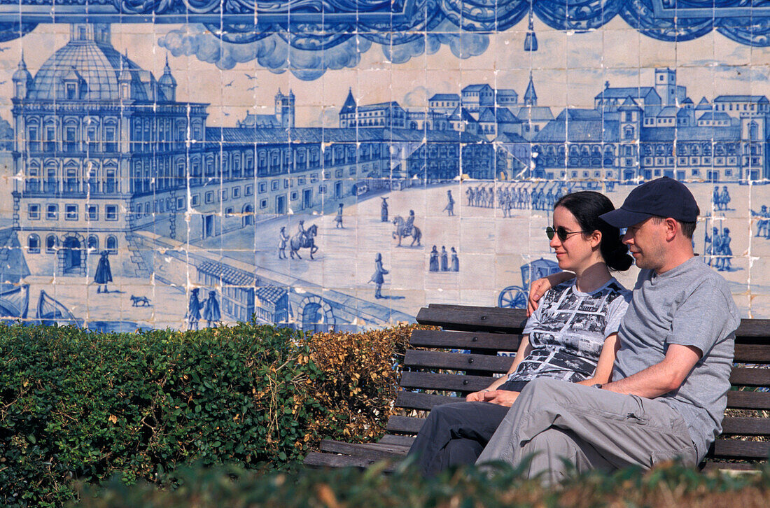 Couple on a bench in front of tiled wall, Azujelos, Miradouro St. Luzia, Alfama, Lisbon, Portugal, Europe