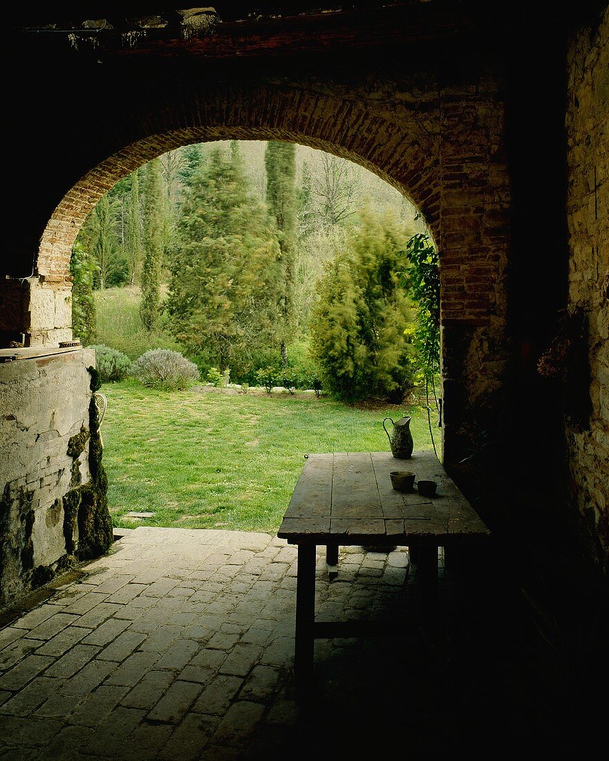 A view through an old archway onto an idyllic garden