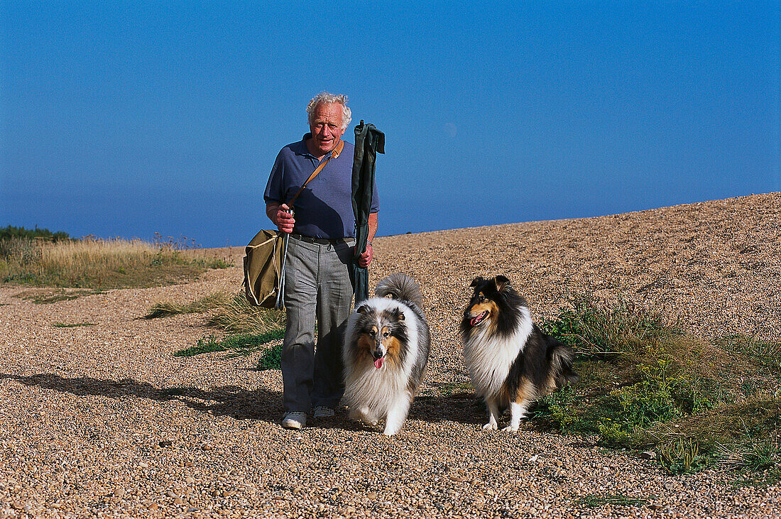 Fisherman and dogs, Chesil Beach, Dorset England