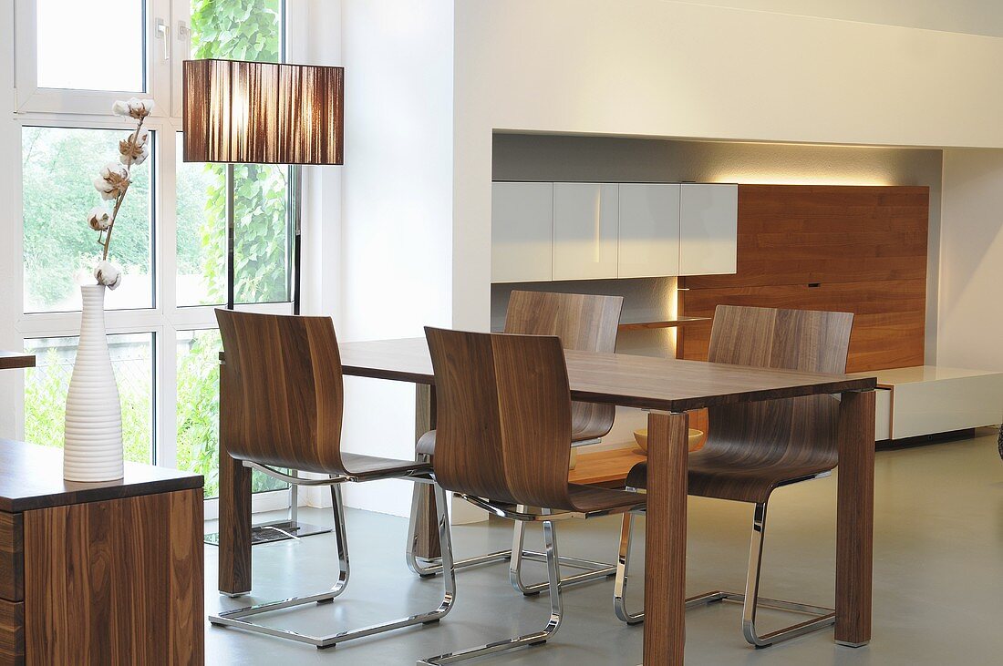 A dining room with a walnut dining table and chairs in designer style