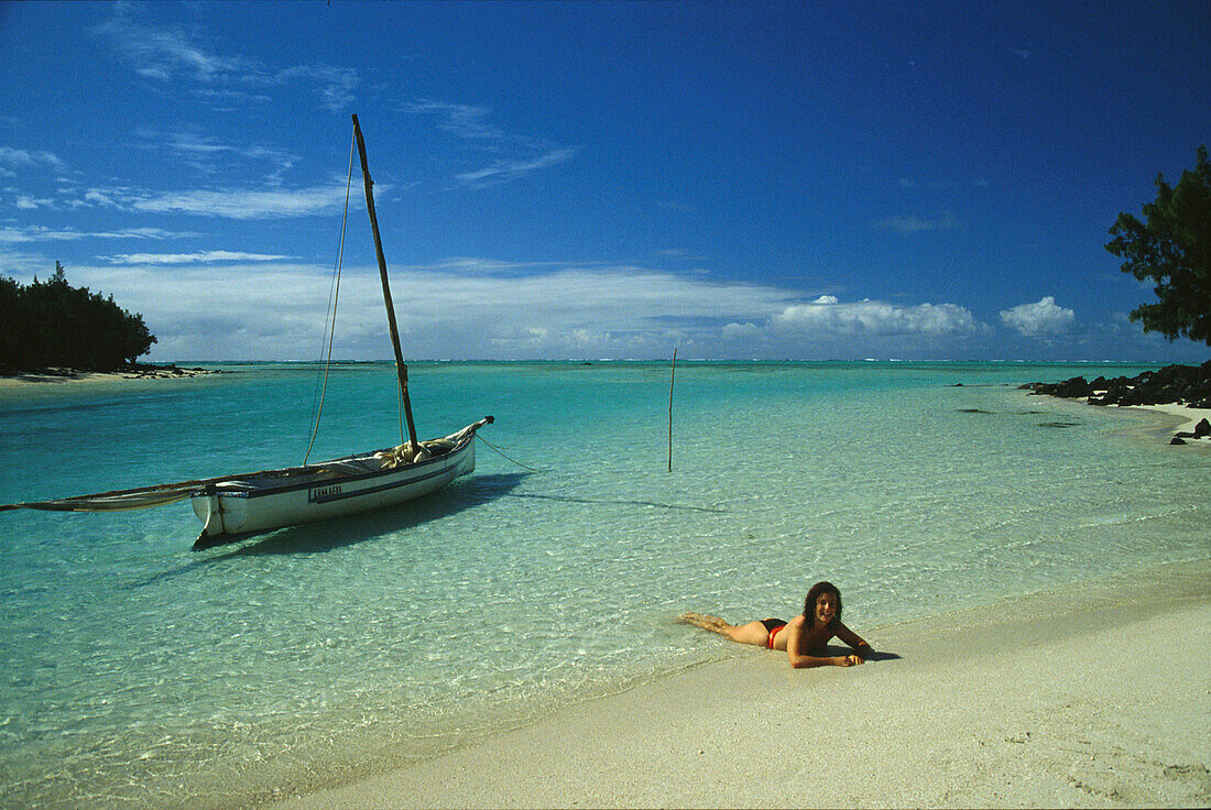 Frau am Strand mit Boot, Ile aux Cerfs, Mauritius