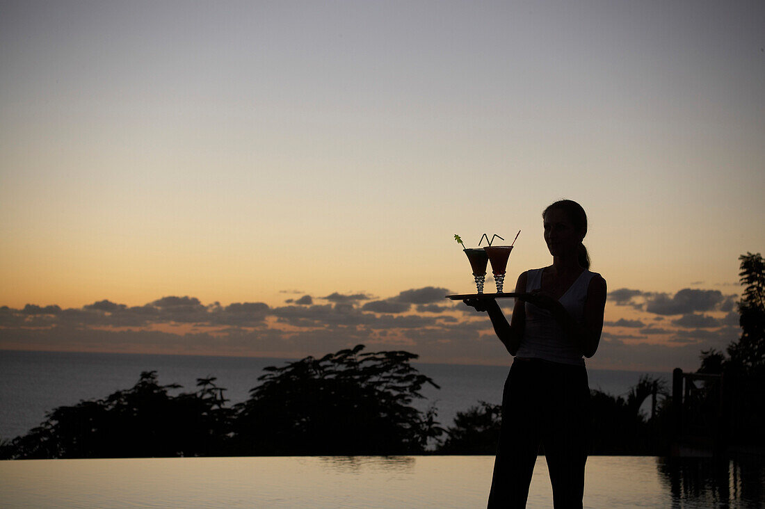Waiter at the pool of Hotel Restaurant Le Rayon Vert in the evening light, Deshaies, Basse-Terre, Guadeloupe, Caribbean Sea, America
