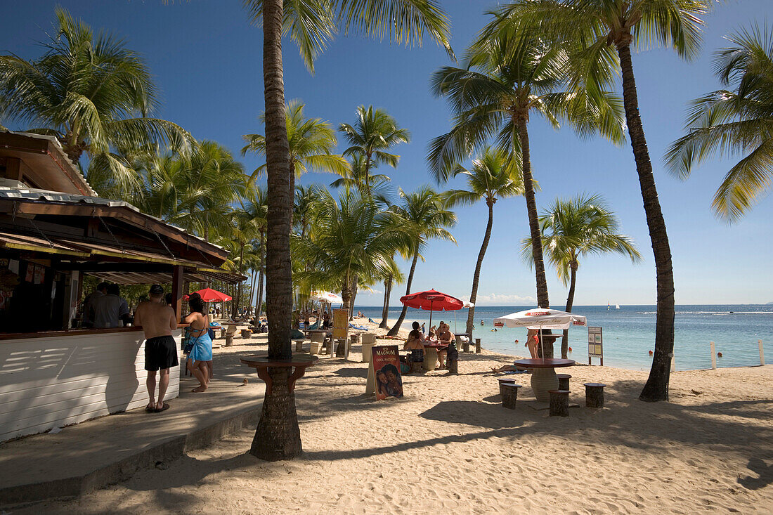 Strandbar und Menschen unter Palmen am Caravelle Beach, Grande-Terre, Guadeloupe, Karibik, Amerika