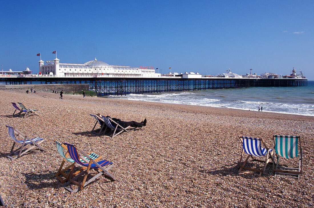 Blick auf Liegestühle am Strand und Palace Pier, Brighton, Sussex, England, Grossbritannien, Europa