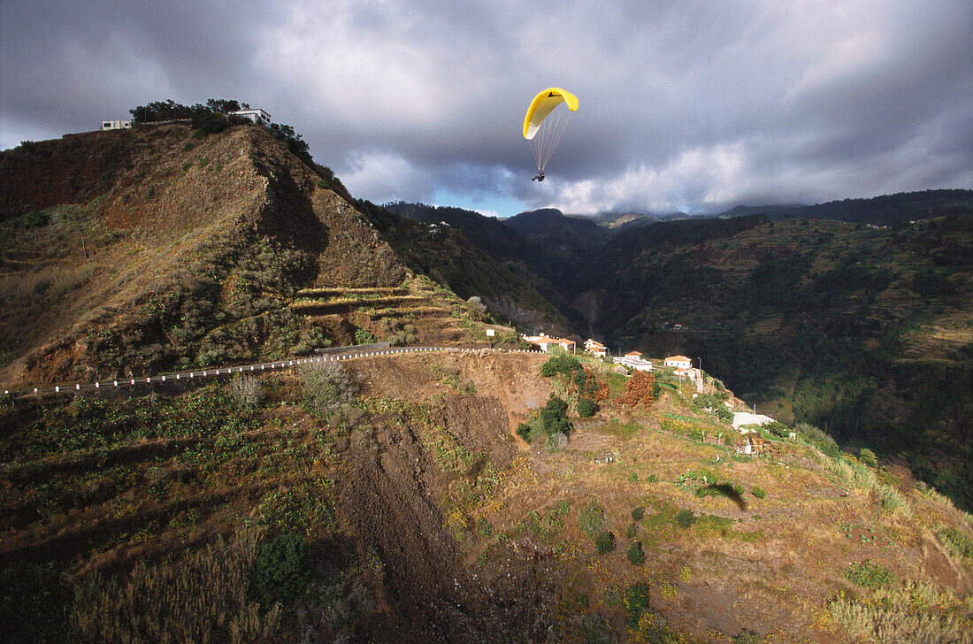Gleitschirmflieger über Berglandschaft, Südküste bei Calheta, Madeira, Portugal