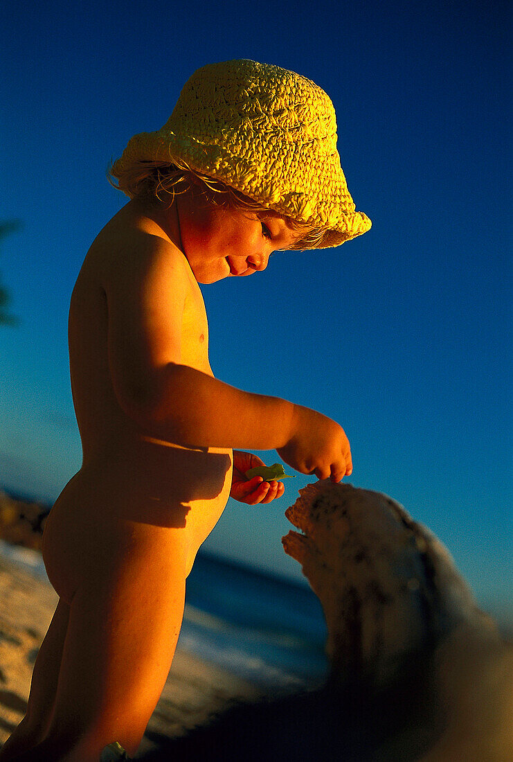 Small girl playing on the beach at sunset, Anse Kerlan, Praslin, Seychelles, Indian Ocean