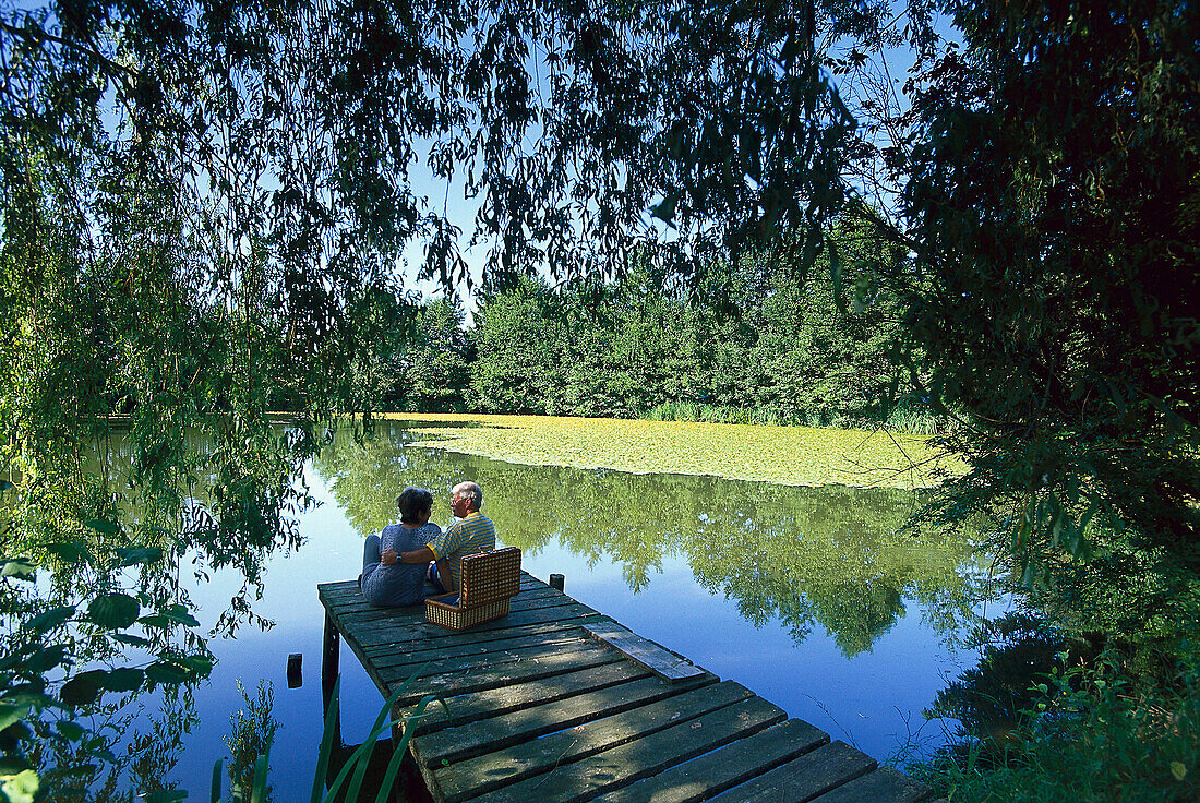 Senior couple having a picnic at lakeshore