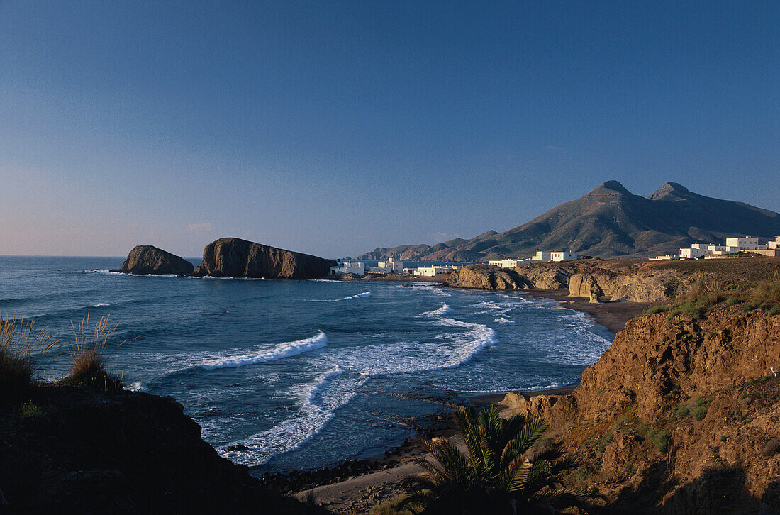 Blick auf Dorf an der Küste im Sonnenlicht, Playa del Peno Blanco, Cabo de Gata, Andalusien, Spanien, Europa