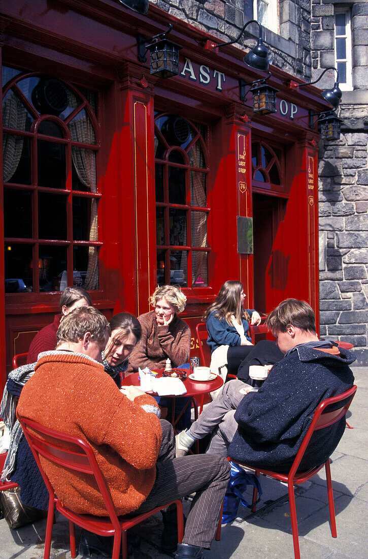 Menschen sitzen vor dem Pub The Last Drop im Sonnenlicht, Grassmarket, Edinburgh, Schottland, Grossbritannien, Europa