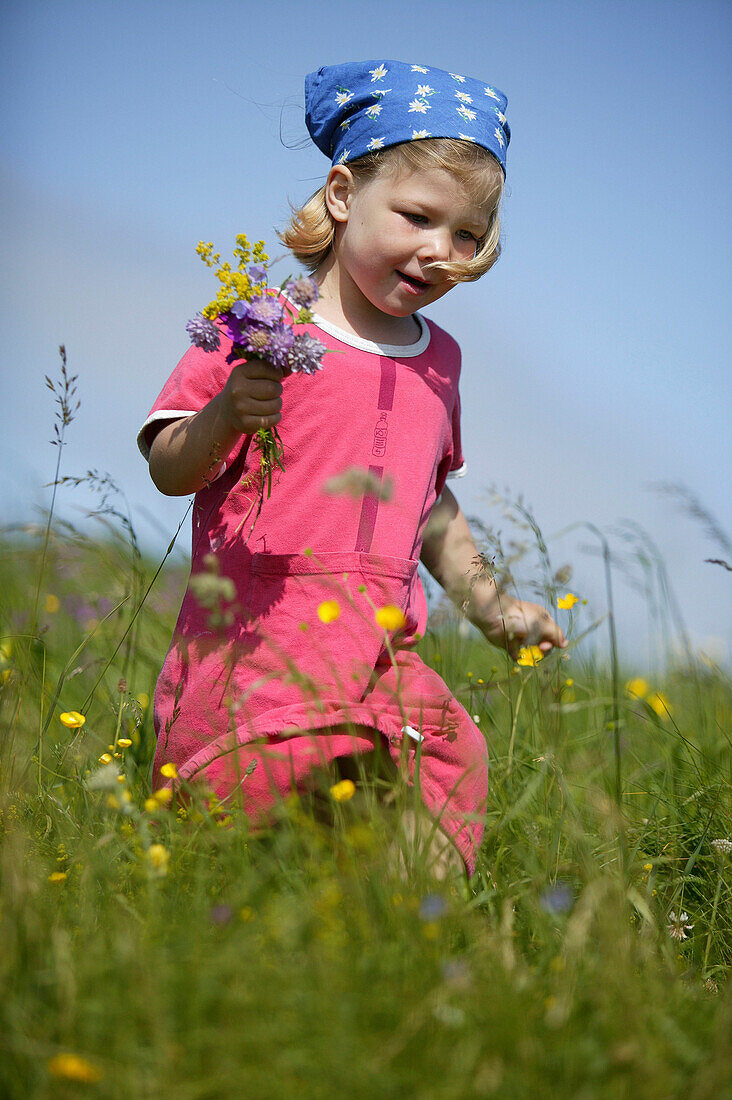 Mädchen mit Blumenstrauss, läuft über Wiese