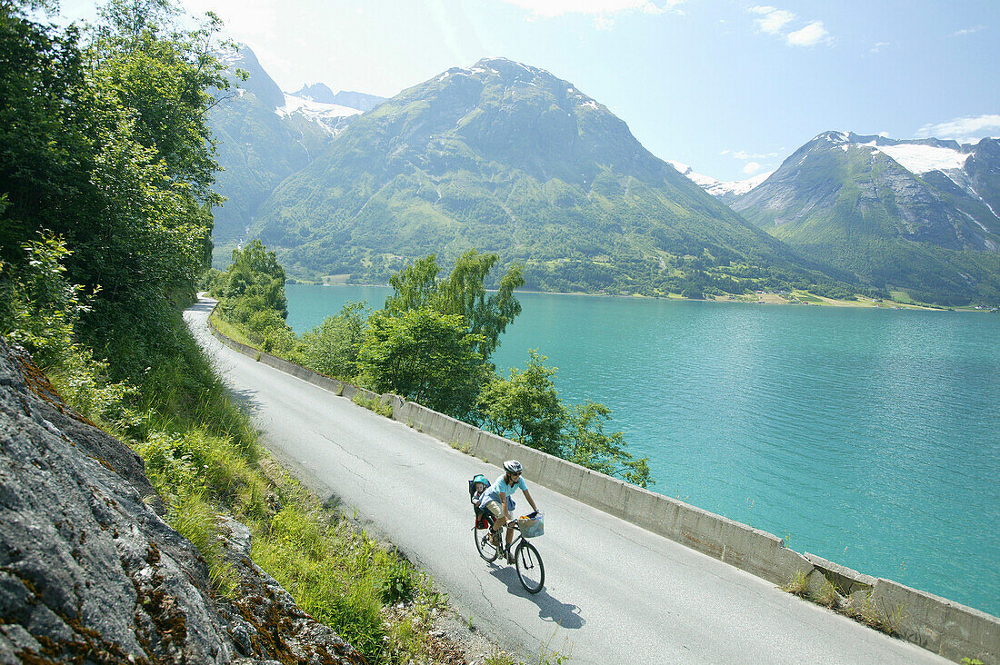 Woman with child on a bicycle, Lake Stryn, Sogn og Fjordane, Norway