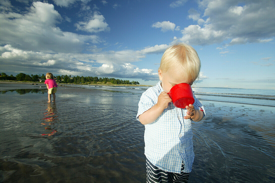Zwei Kinder spielen am Strand, Tönsberg, Vestfold, Oslofjord, Norwegen