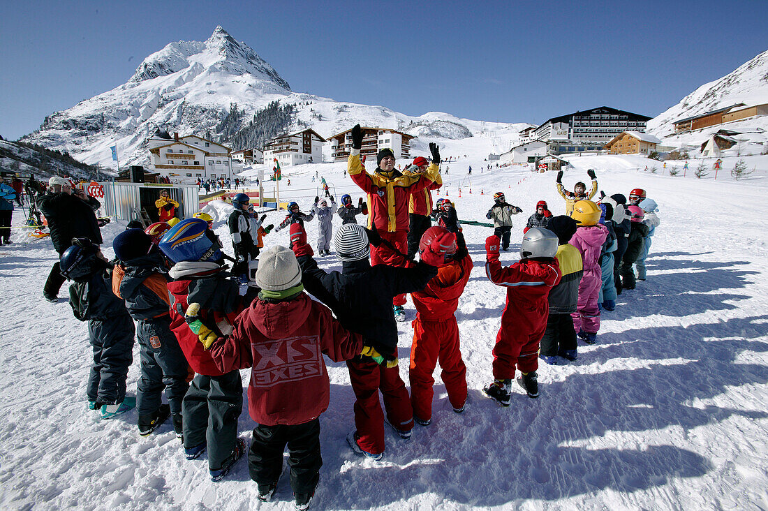 Skischule, Kinder und Skilehrer wärmen sich auf, Skiunterricht, Wirl in der Nähe von Galtür, Tirol, Österreich