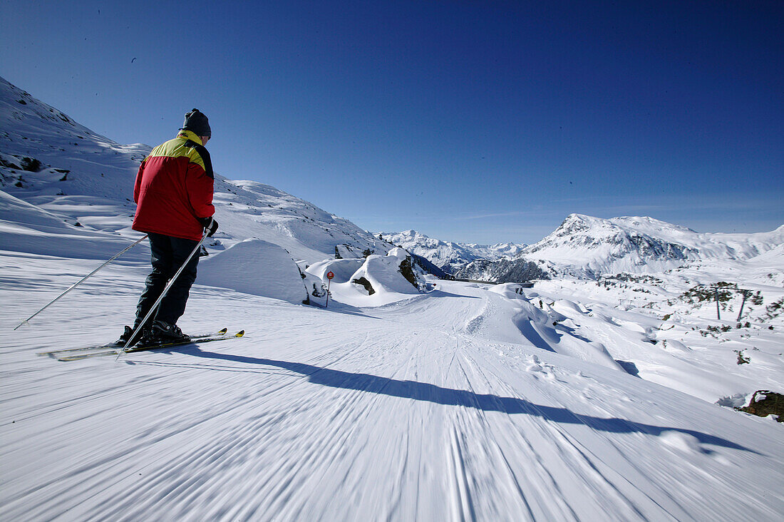 Man skiing downhill, Kops lake in the background, Galtuer, Tyrol, Austria