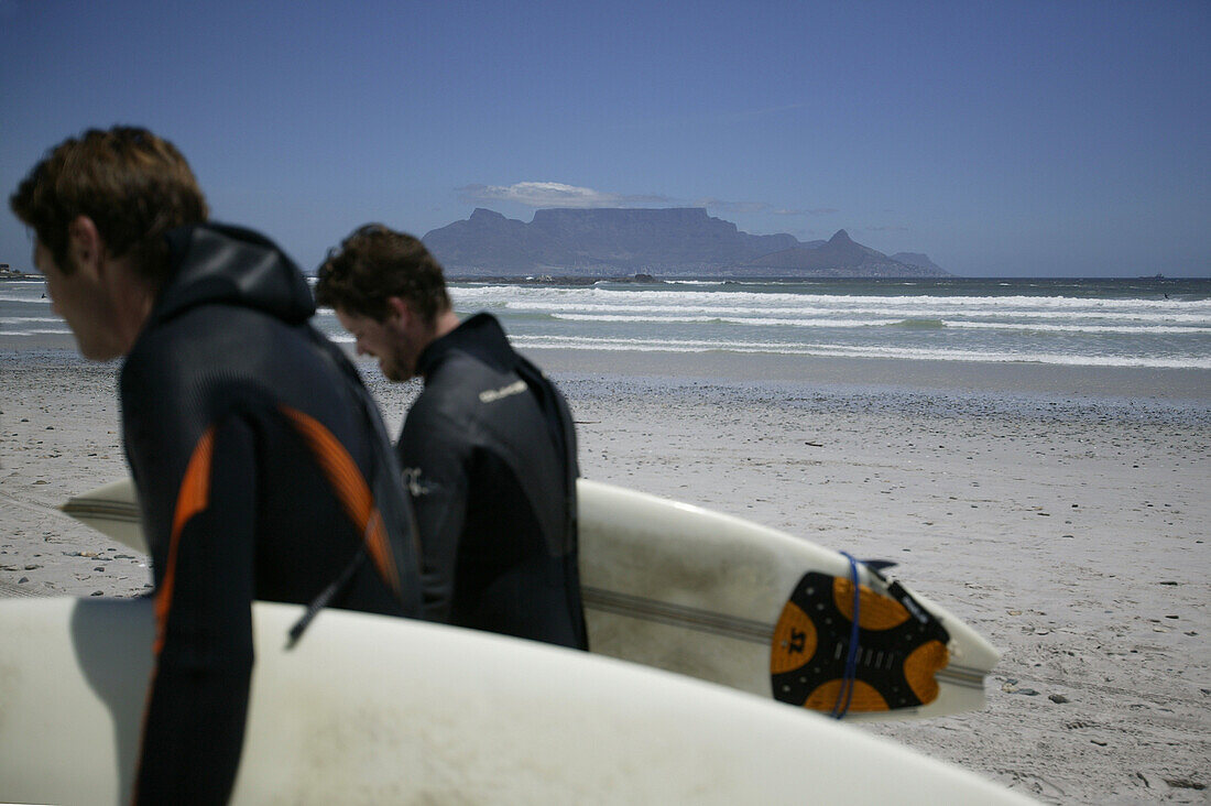 Surfers passing, Beach, Bloubergstrand, Table Mountain in background, Western Cape, South Africa