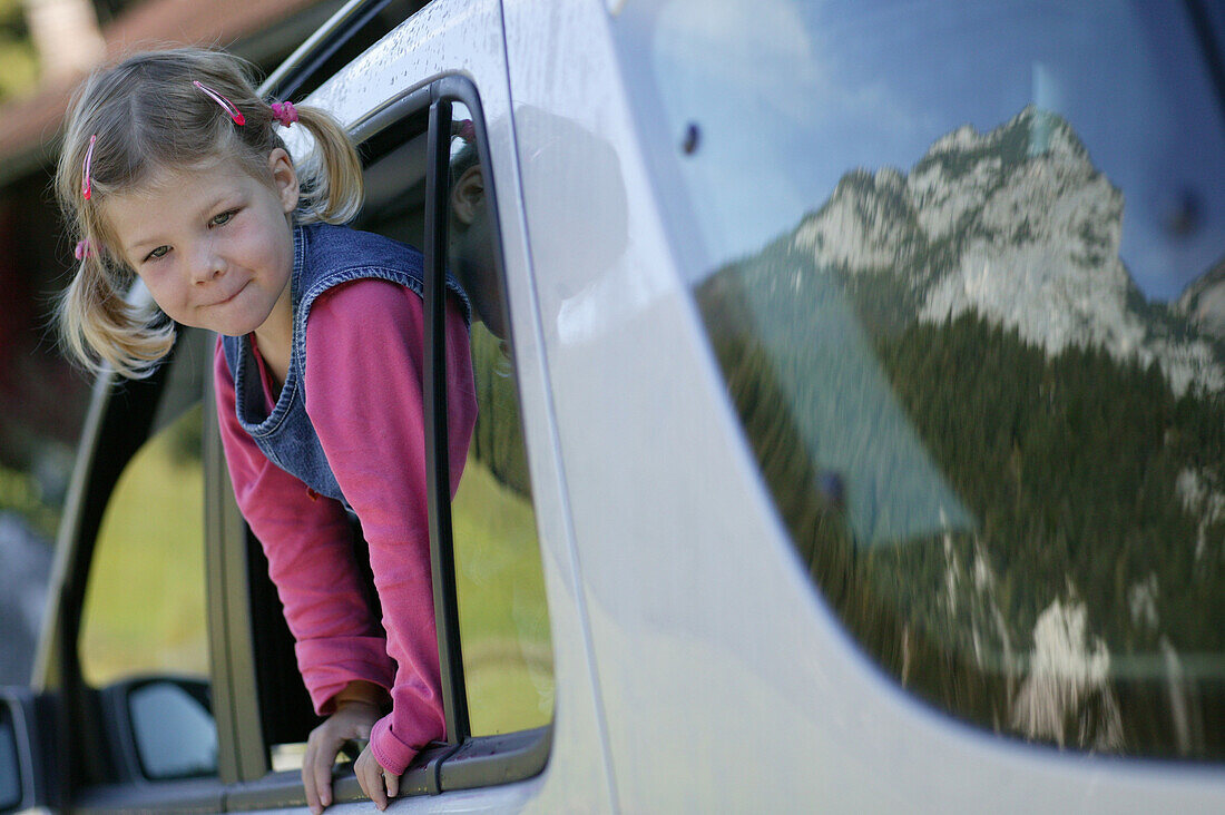 Young girl looking out the car window, reflection of mountains in the car window, Alpine road, Reiteralpe, Ramsau, Bavaria, Germany