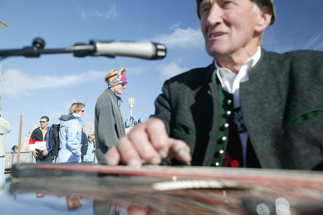 Alter Mann spielt auf der Zither, Gipfelkreuz, Zugspitze, Garmisch, Oberbayern, Bayern, Deutschland