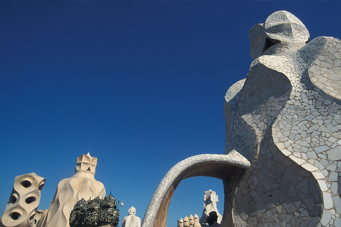 Sculptures on the roof of Casa Mila under blue sky, Barcelona, Spain, Europe