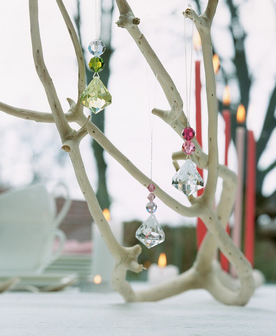 A branch decorated with glass pendants and candles