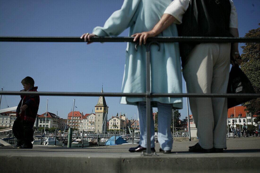 Tourists at harbour of Lindau, Couple at harbor of Lindau, Lake Constance, Bavaria, Touristen, an der Mole des Hafens der Altstadt Lindau, Bayern, Deutschland