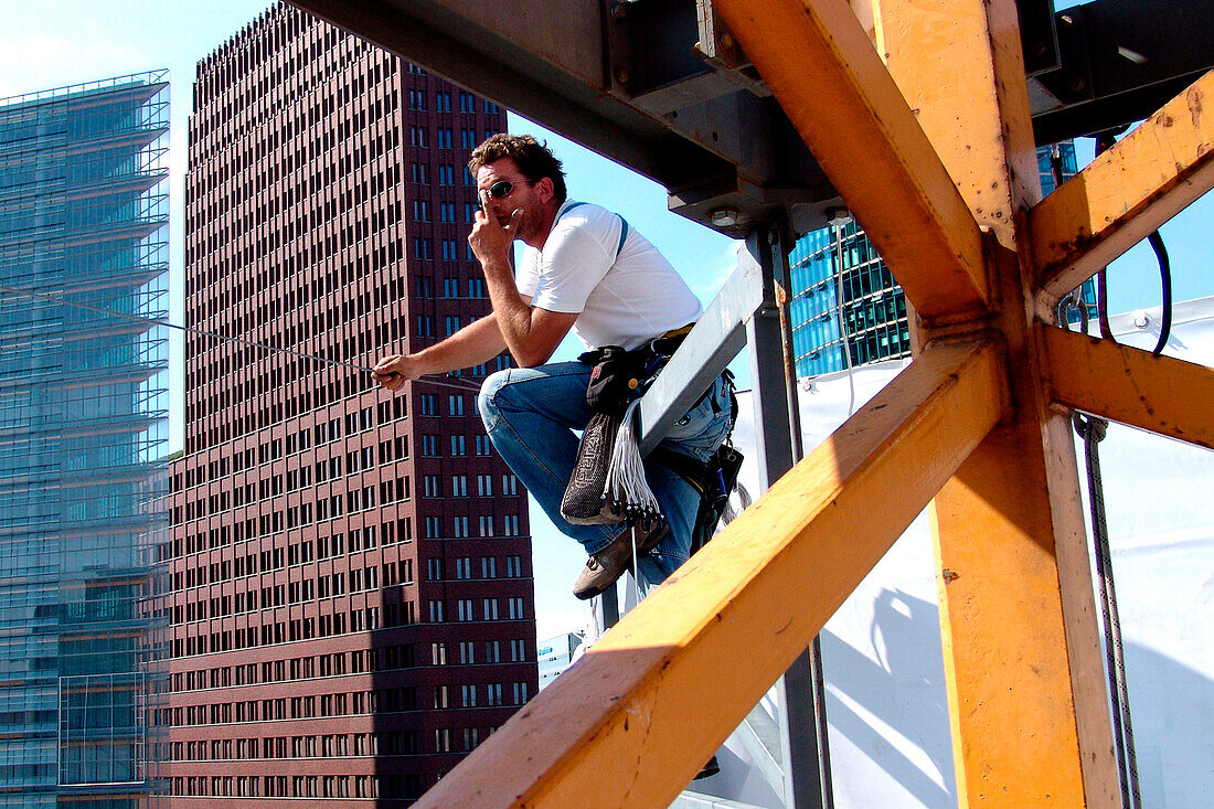 Climber between crane and high rise buildings, Berlin, Germany, Europe