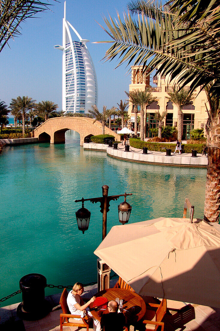 Menschen in einem Restaurant am Kanal und das Hotel Burj al Arab, Dubai, Vereinigte Arabische Emirate, Vorderasien, Asien