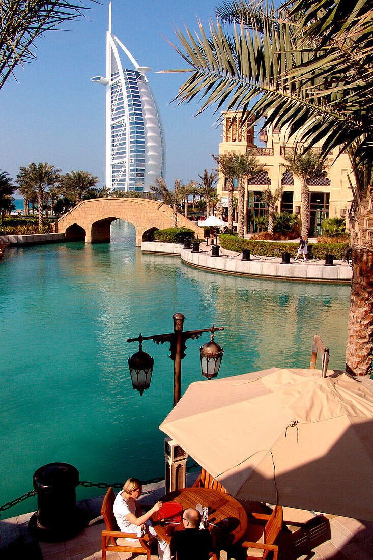 People in a restaurant at the canal and the Burj al Arab hotel, Dubai, United Arab Emirates, Middle East, Asia