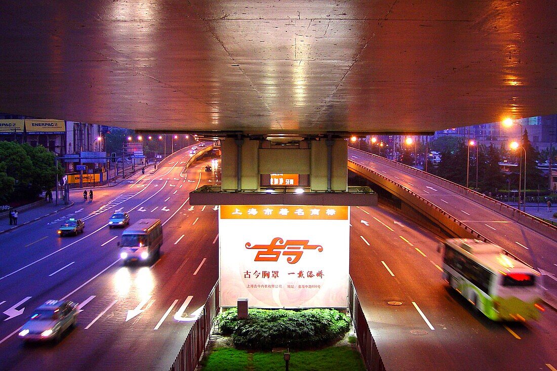 Beleuchtetes Werbeplakat und Schnellstrasse mit Autos am Abend, Shanghai, China, Asien