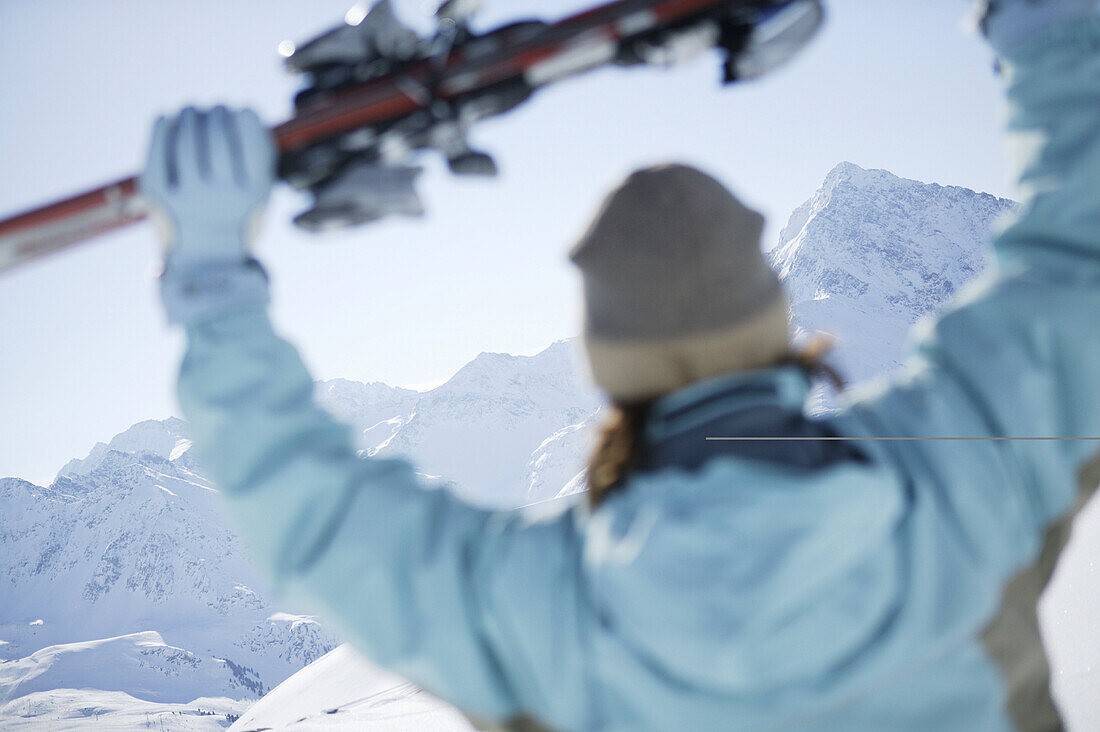 Woman holding skis, Kühtai, Skifahrerin, Hohe Mut und Gaiskogel im Hintergrund, Kühtai, Tyrol, Austria