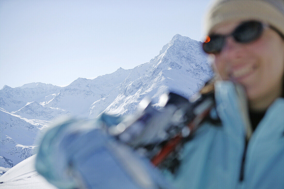 Frau trägt Skier, Berge im Hintergrund, Kühtai, Tirol, Österreich