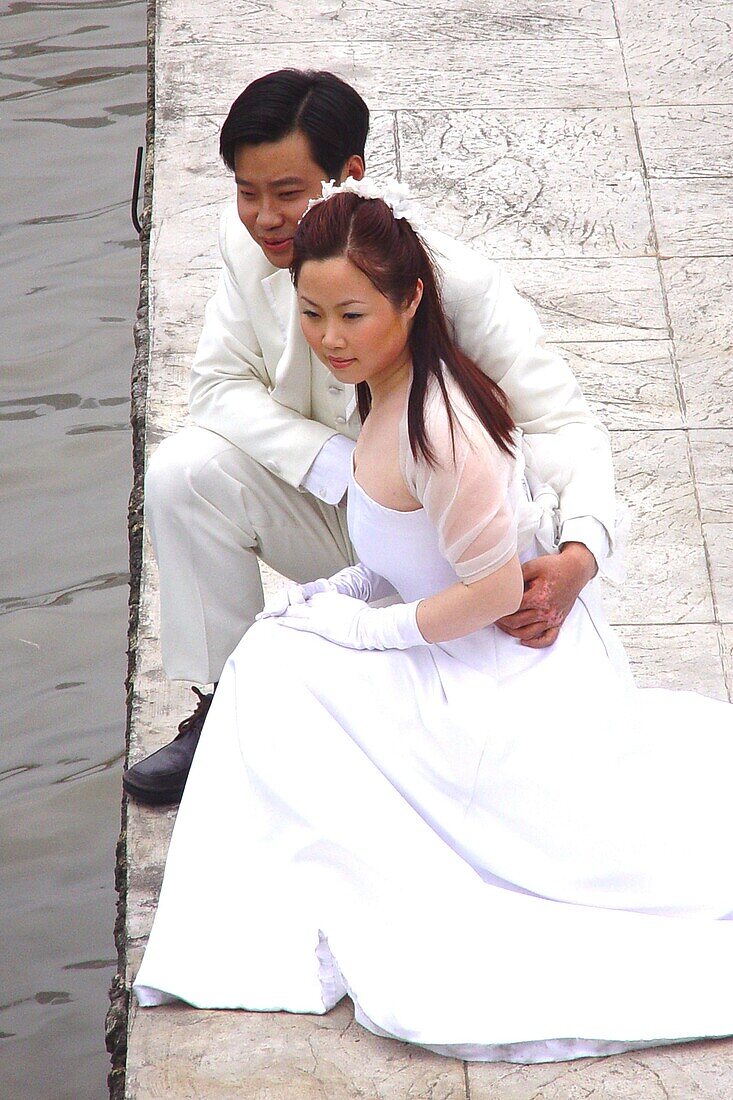 Brautpaar posiert am Flussufer, Shanghai, China, Asien