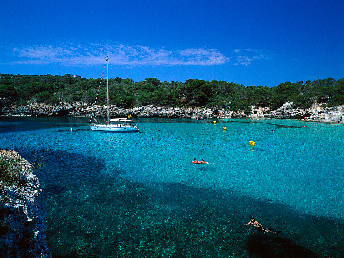 People swimming in the bay at Cala Turqueta, Minorca, Spain