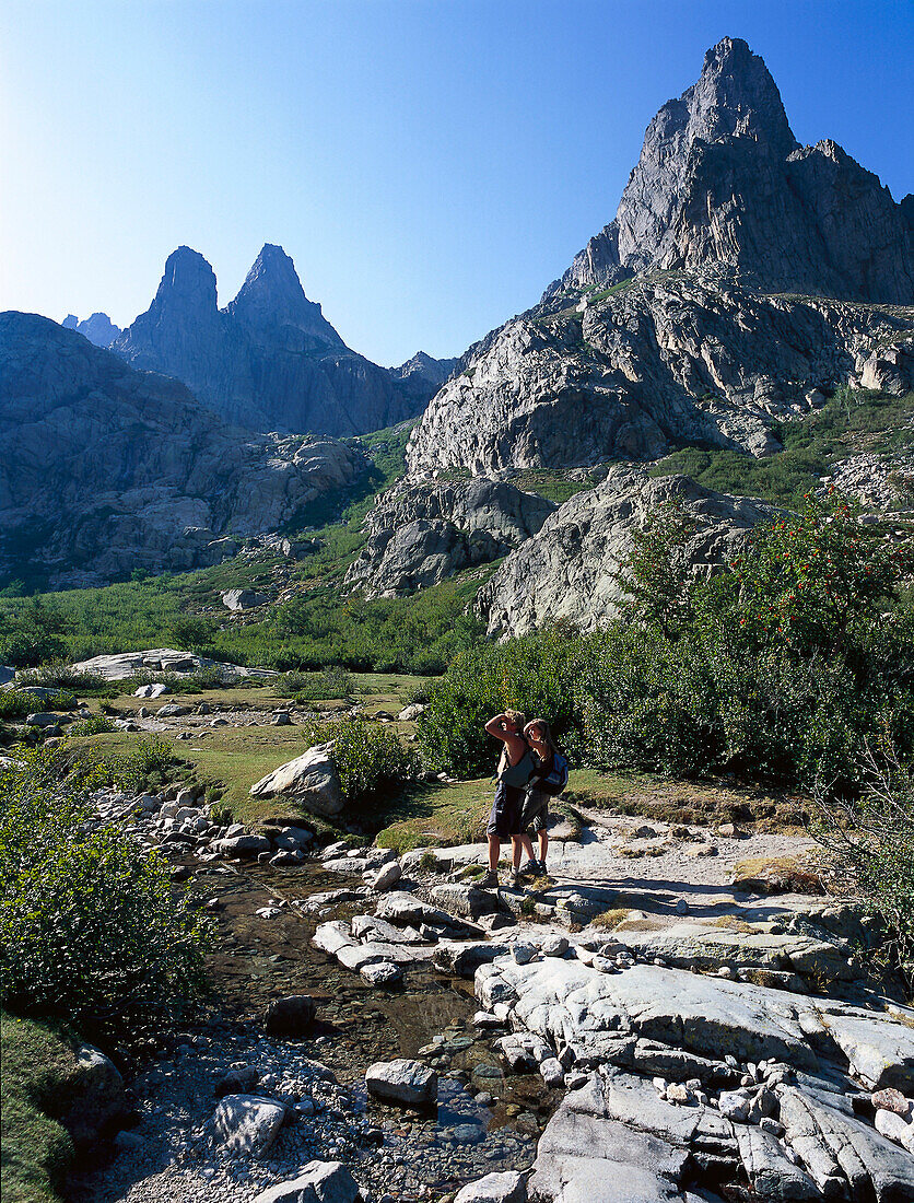 Two people hiking near Lac de Melo Gorges de la Restonica, Corsica, France