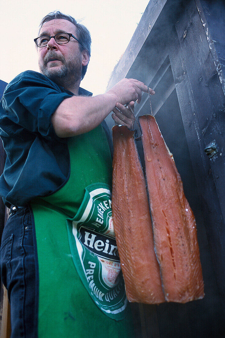 Mann bringt Lachs ins Räucherkammer, Nord Trondelag, Norwegen