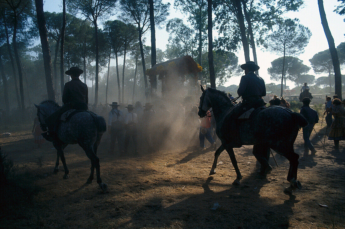 Pilgrims travelling afoot and on horseback on the sandy Raya Real, Andalusia, Spain