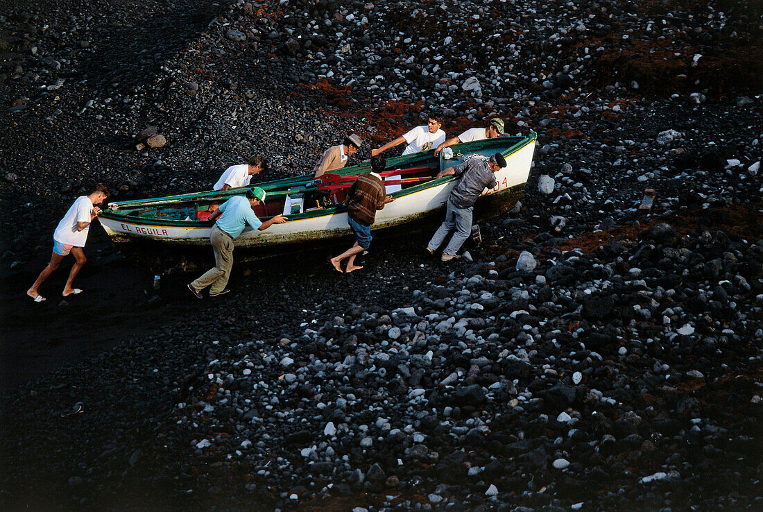 Fischer heben Boot auf den vulkanischen Strand Punta de Fuencaliente, La Palma, Kanarische Inseln, Atlantik, Spanien