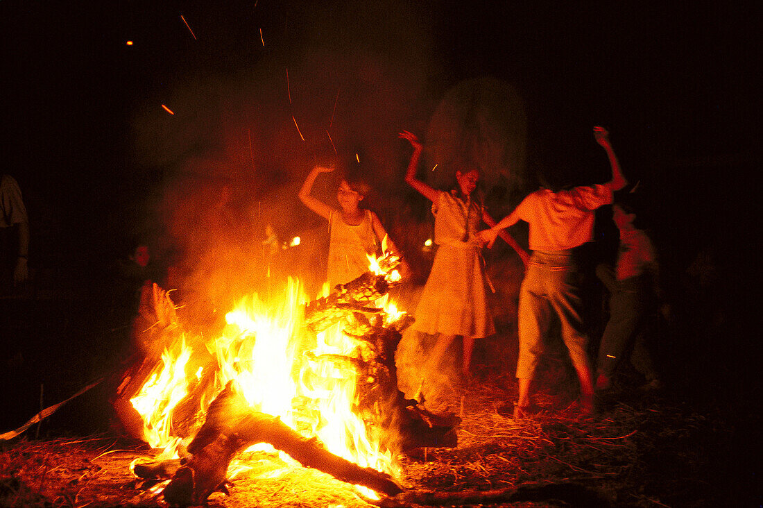 Junge Pilger tanzen Sevillanas neben einem Lagerfeuer am Abend, Romería al Rocío, El Rocío, Pilgerfahrten, Andalusien, Spanien