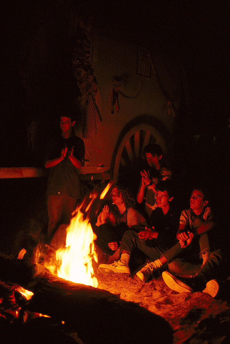 Pilger sitzen nachts um ein Lagerfeuer, Andalusien, Spanien