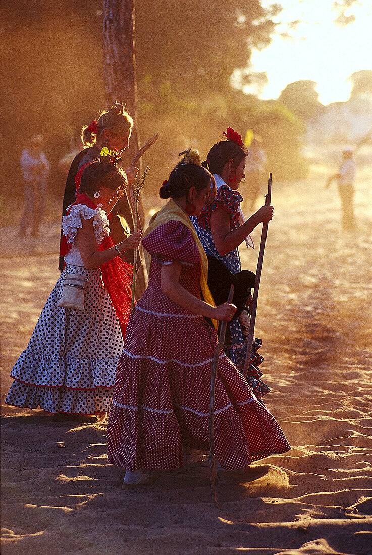 Pilgerinnen laufen mit Wanderstöcken über sandige Strasse, Andalusien, Spanien